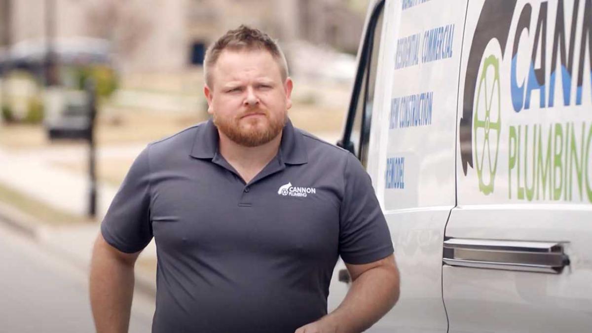 A man walking alongside a utility van.