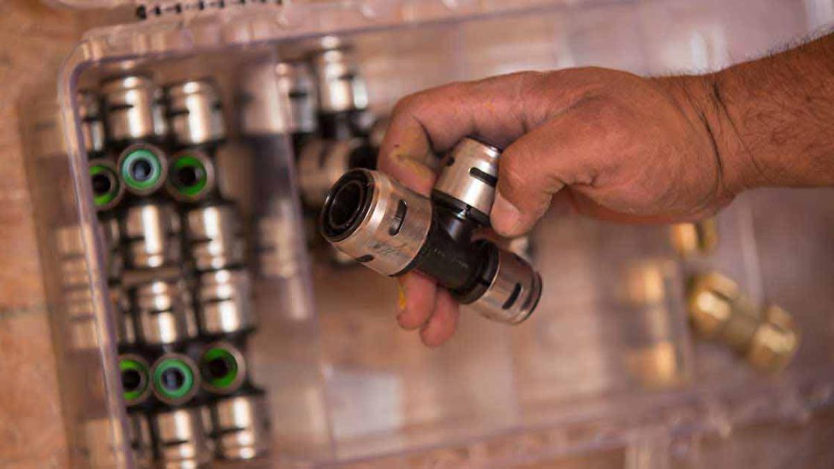 EvoPEX push-to-connect plumbing fittings displayed on a workbench, showcasing efficient installation solutions for modern residential plumbing systems.