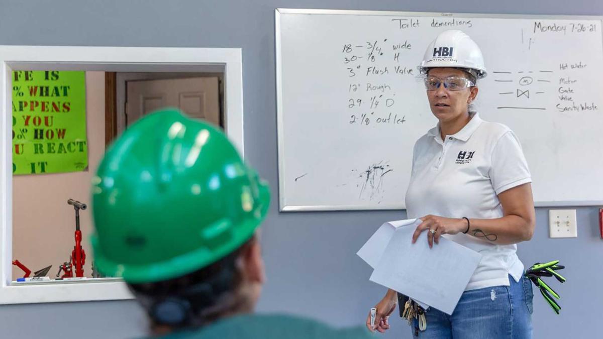 Female plumbing instructor teaching apprentice 