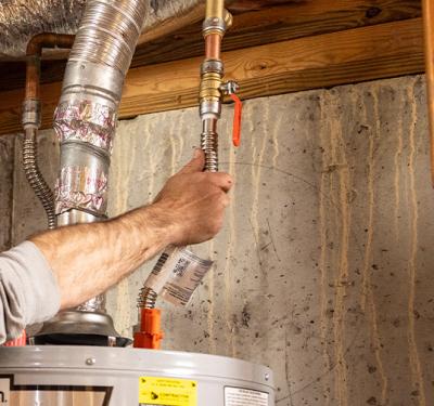 A plumber installing a SharkBite Max Push-to-Connect Water Heater Connection Kit