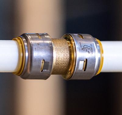 SharkBite brass push-to-connect coupling connecting PEX and copper pipe with secure, tool-free installation for multi-pipe compatibility