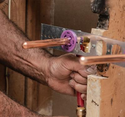 SharkBite brass push-to-connect plumbing manifold system shown on home blueprint dplumber installing SharkBite brass push-to-connect stub-out elbow during rough-in phase, allowing for pressure testing before fixture installation with secure, tool-free connection for exposed copper or PEX pipe
