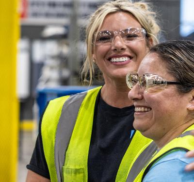 Two SharkBite production workers smiling