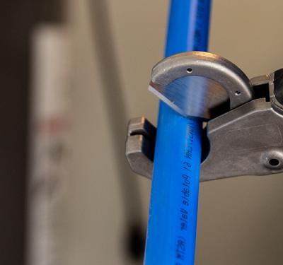 Professional SharkBite PEX installation tools featuring precision pipe cutters and the essential PEX crimp tool for secure, leak-free connections in plumbing installations