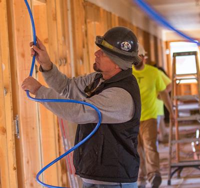 A plumber installing SharkBite PEX in a new home build