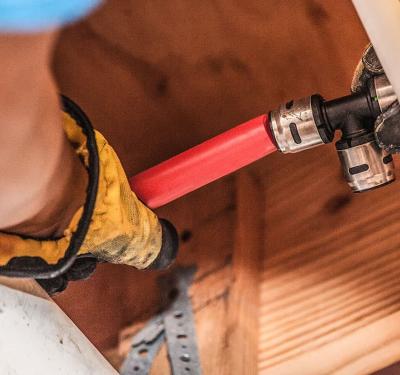 PEX tubing connected in a tight space using SharkBite fittings for compact plumbing solutions