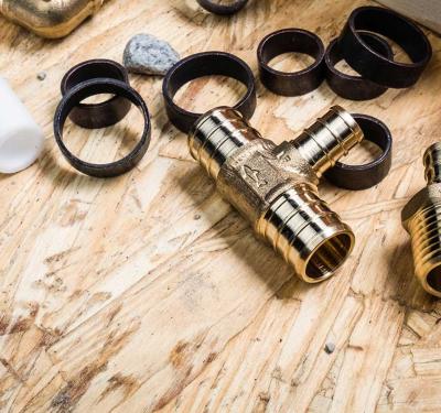 SharkBite brass crimp adapter tee, PEX rings, and ball valve for PEX plumbing systems