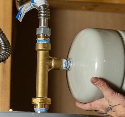 A plumber repairing a water heater with SharkBite products