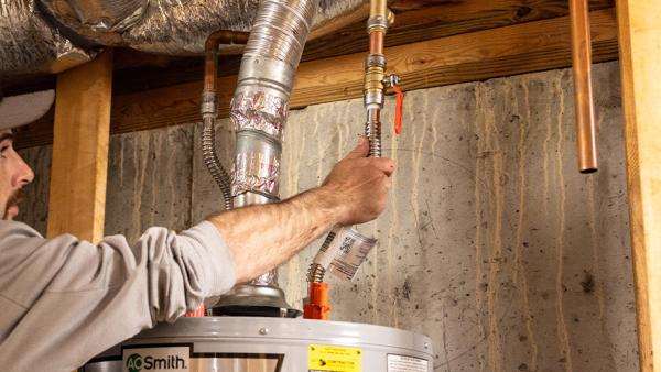 A plumber installing a SharkBite Max Push-to-Connect Water Heater Connection Kit