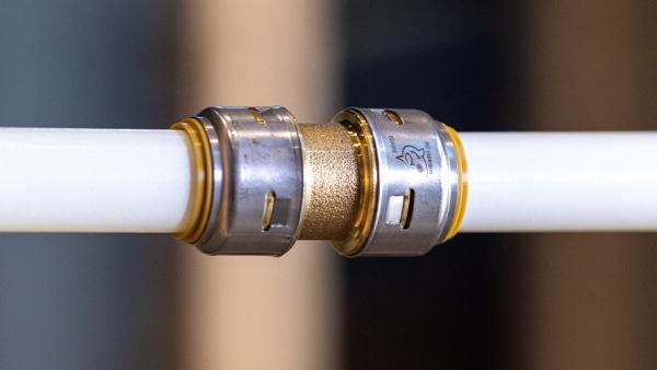 SharkBite brass push-to-connect coupling connecting PEX and copper pipe with secure, tool-free installation for multi-pipe compatibility