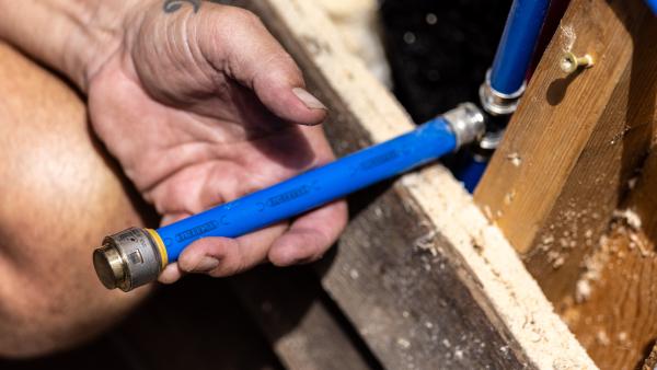 SharkBite end cap on a blue PEX pipe