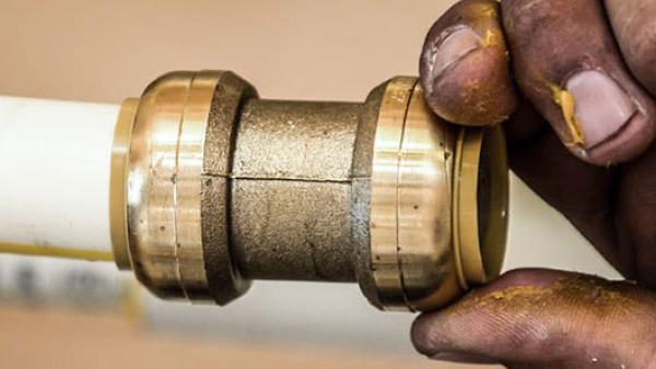 First generation push-to-connect coupling fitting for joining pipes in residential and commercial plumbing systems