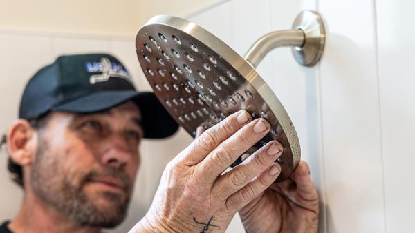 A plumber installing a shower fixture