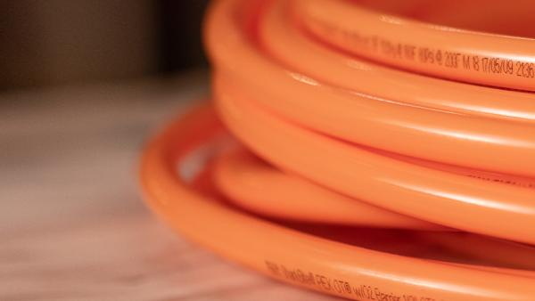 SharkBite oxygen barrier PEX tubing coil designed specifically for radiant floor and hydronic heating systems, preventing oxygen permeation for enhanced system longevity