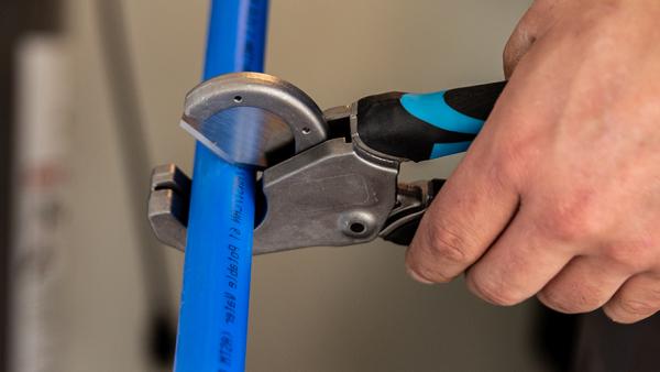 Professional SharkBite PEX installation tools featuring precision pipe cutters and the essential PEX crimp tool for secure, leak-free connections in plumbing installations