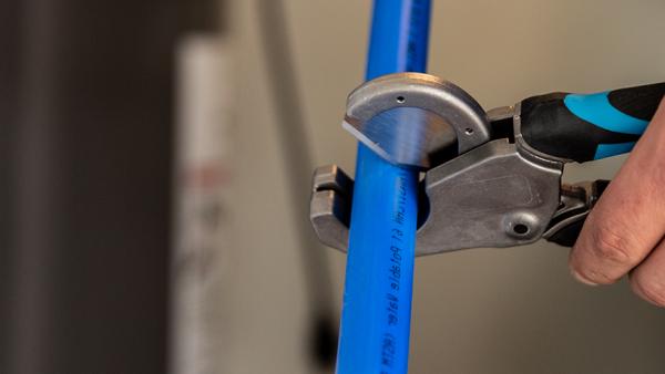 Professional SharkBite PEX installation tools featuring precision pipe cutters and the essential PEX crimp tool for secure, leak-free connections in plumbing installations