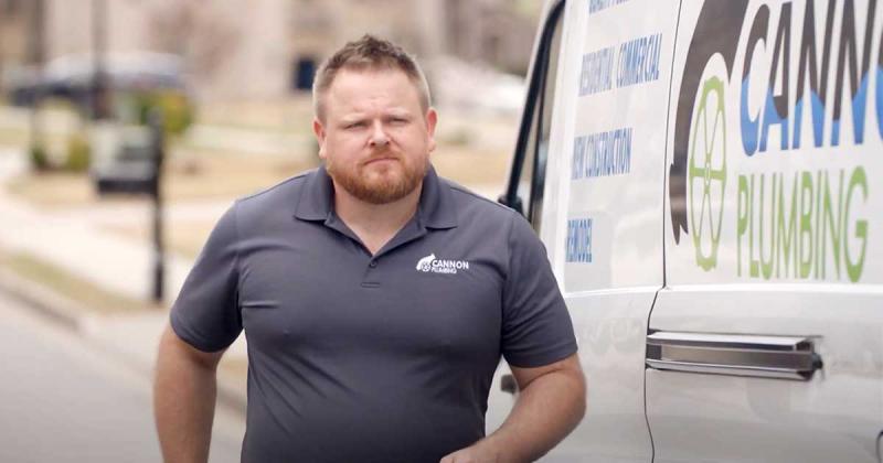 A man walking alongside a utility van.