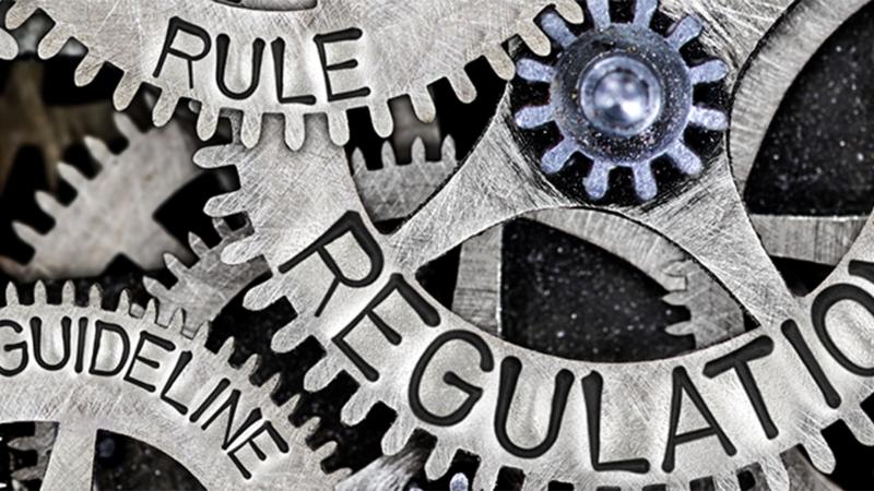 Photo of Gears with the words "rules", "regulation" and "guideline" written on them.