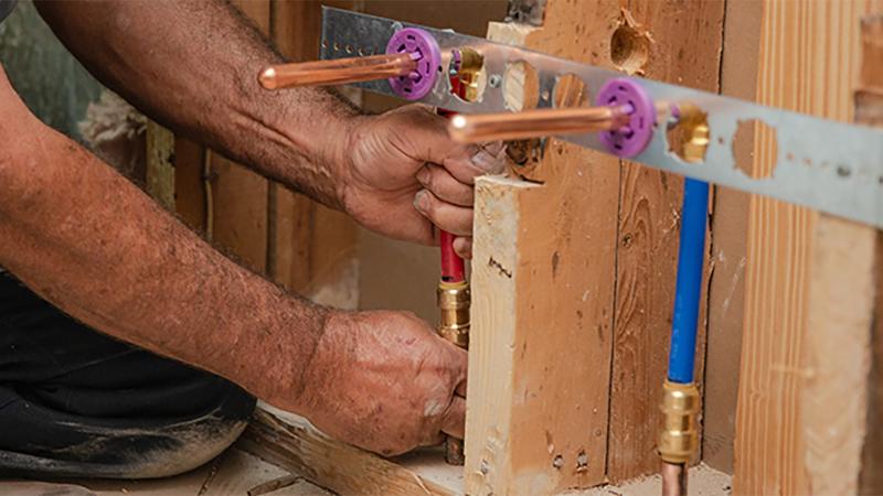 Connecting copper pipe to PEX tubing using SharkBite push-to-connect plumbing fittings.