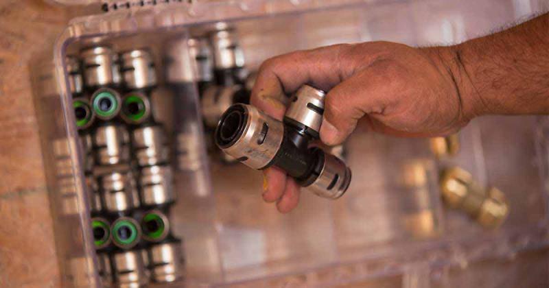 EvoPEX push-to-connect plumbing fittings displayed on a workbench, showcasing efficient installation solutions for modern residential plumbing systems.