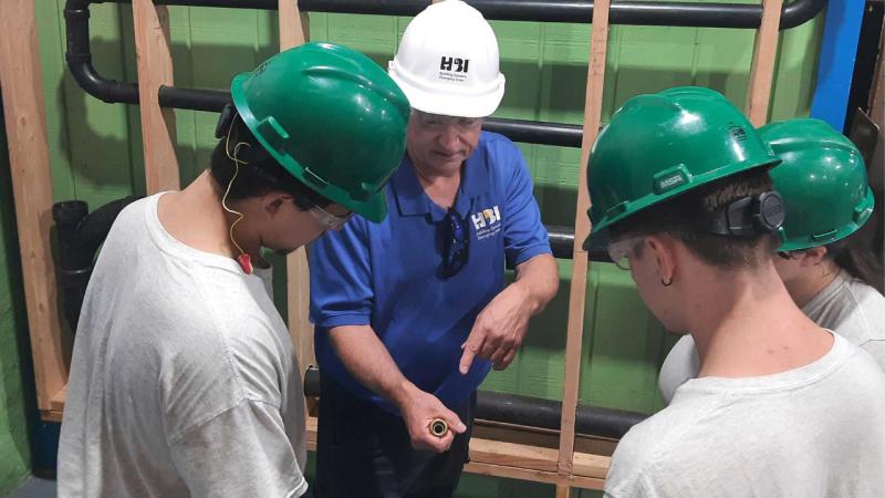 instructor john gallagher shows hbi students a push-to-connect fitting