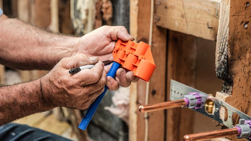 plumber using deburr and gauge tool